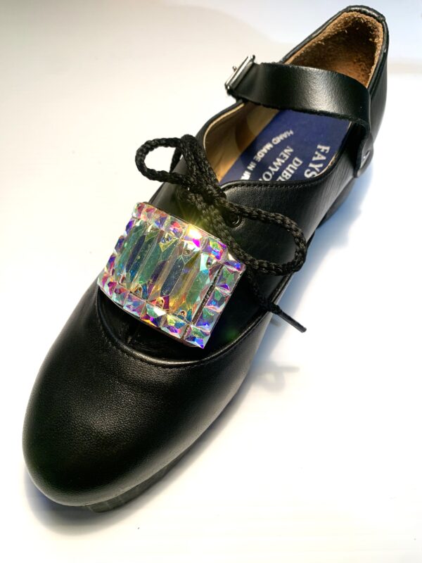 A pair of black shoes with a crystal buckle.