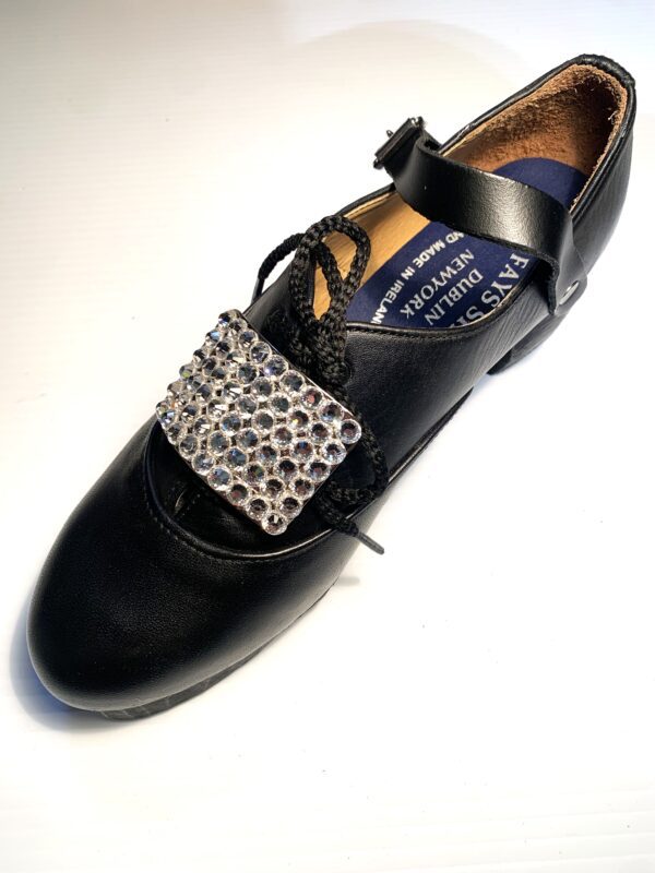 A pair of black shoes with clear crystal buckles.